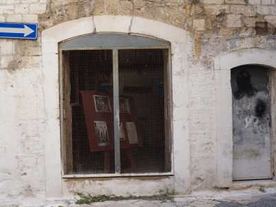 Alla porta d�accesso del piano terra, chiusa da una grata arrugginita, si affianca una pi� piccola entrata, forse aggiunta successivamente, serrata da un uscio metallico